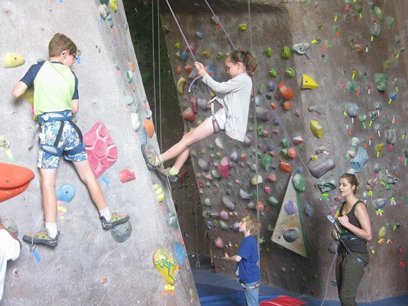 mother advising children how to rock climb