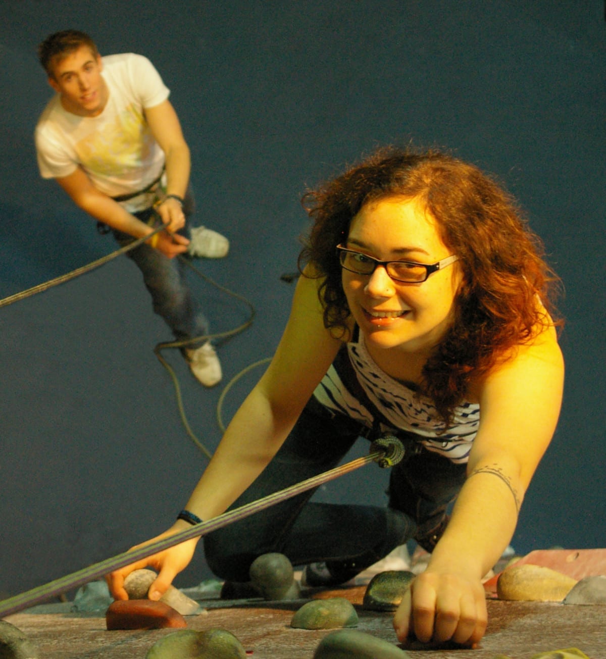 girl rock climber looking up and smiling