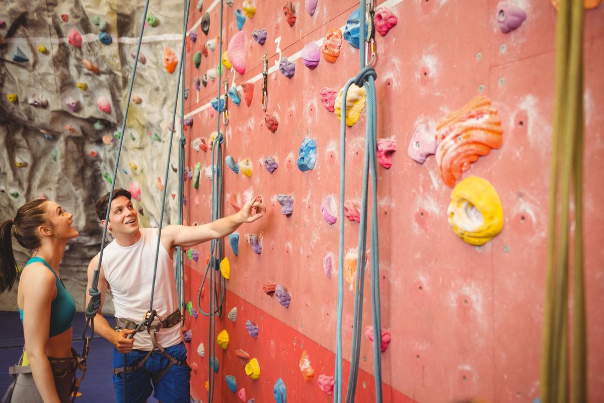 instructor showing how to use indoor rock climbing